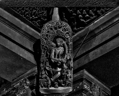 Chennakeshava temple, Beluru, A madanika dressing her hair, atop one of the central column of the mandapa, p50